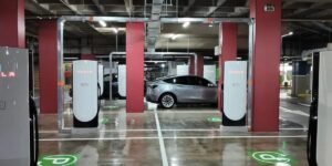 Estación Supercharger de Tesla en el parqueadero del Centro Comercial Andino de Bogotá, con un Tesla Model Y plateado cargando entre los postes