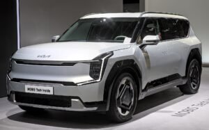 Kia EV9 eléctrico de seis plazas visto de tres cuartos delantero en un salón del automóvil